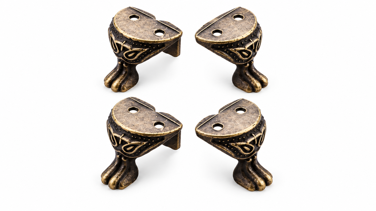 Four antique bronze decorative furniture feet on white background